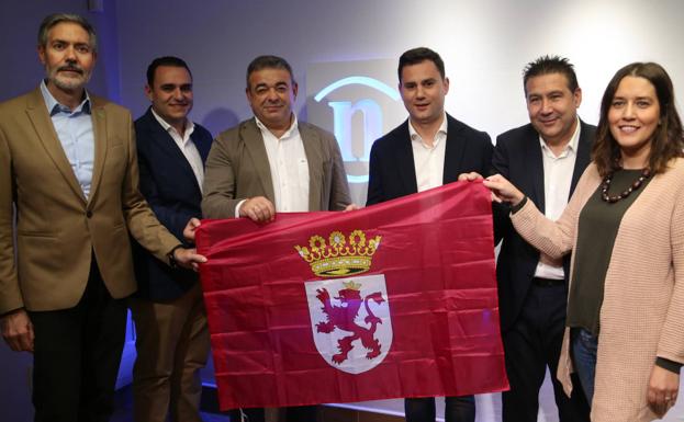 Los candidatos sostienen la bandera de León. 