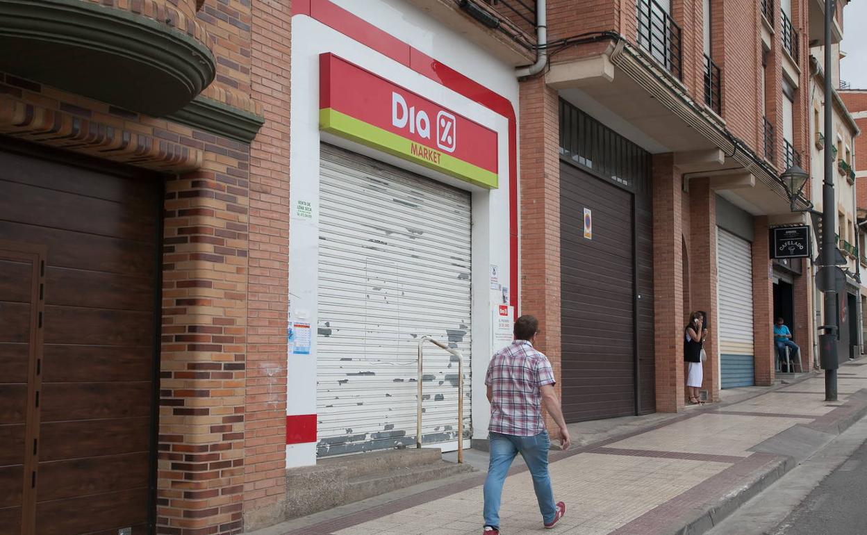 Una persona camina delante de una tienda de Dia cerrada.