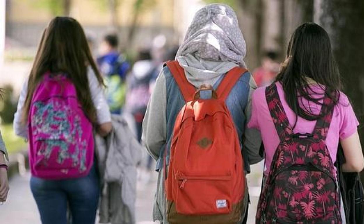 Un niña musulmana con velo y vestimenta de manga larga. 