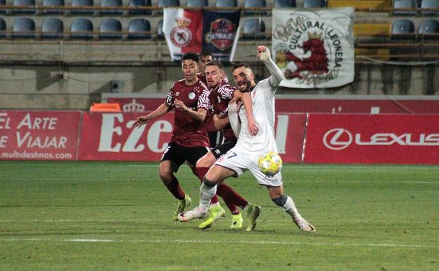 Galería. Pugna por un balón durante el partido.