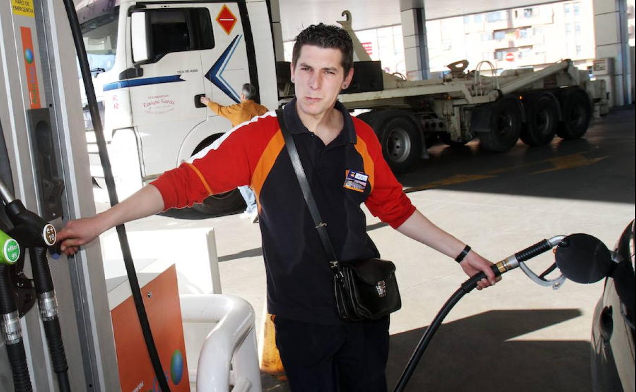 Un empleado llena un depósito de gasolina.