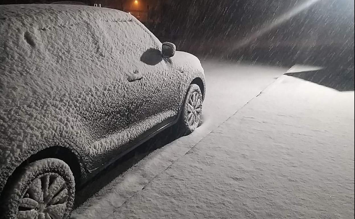 Imagen de un coche nevado en el puerto de Pajares.