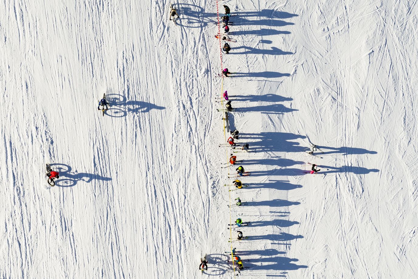 Fotografía realizada por un dron que muestra a varios ciclistas participando en la San Silvestre por la nieve en la estación de esquí de Villars-Sur-Ollon, Suiza.