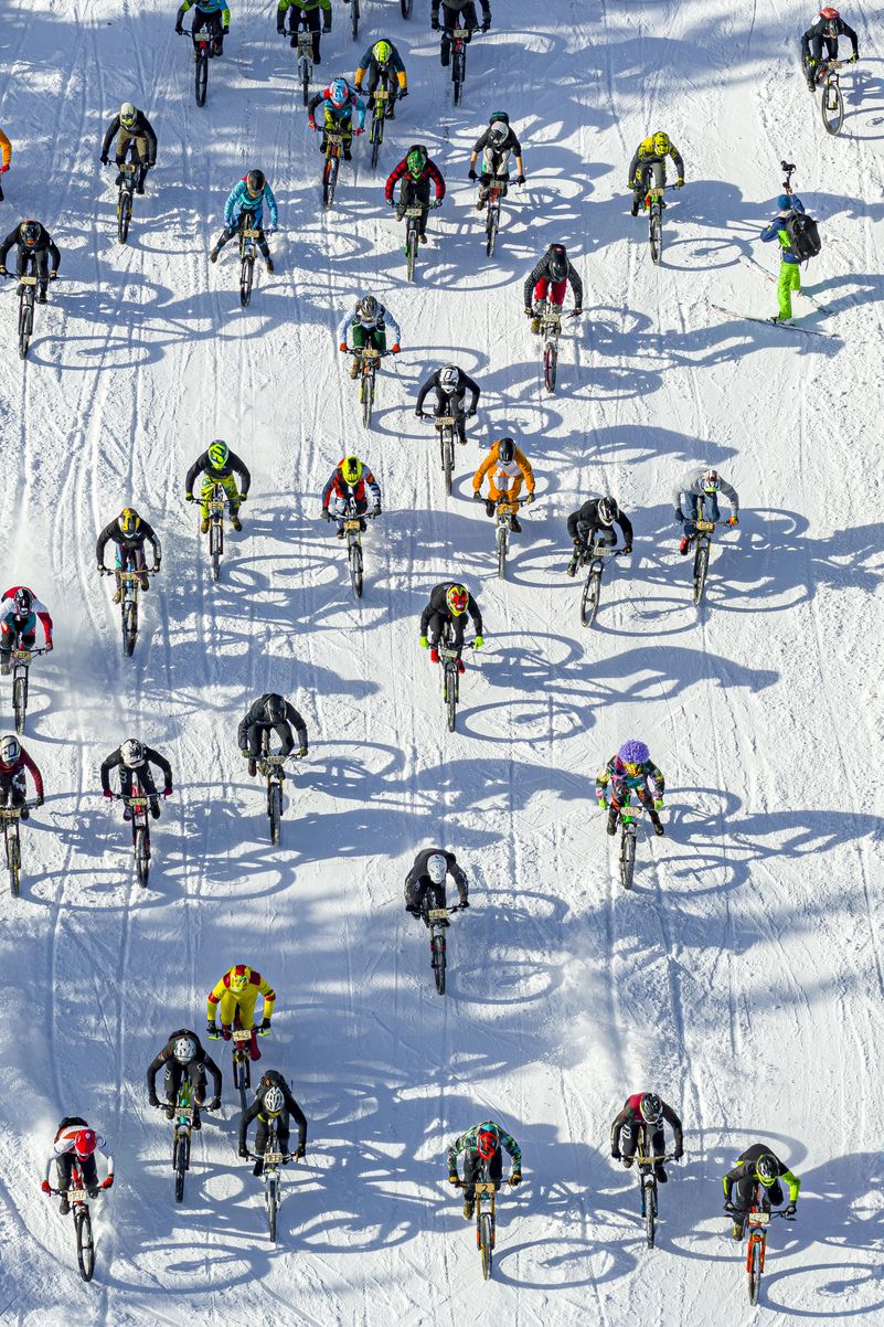 Fotografía realizada por un dron que muestra a varios ciclistas participando en la San Silvestre por la nieve en la estación de esquí de Villars-Sur-Ollon, Suiza.