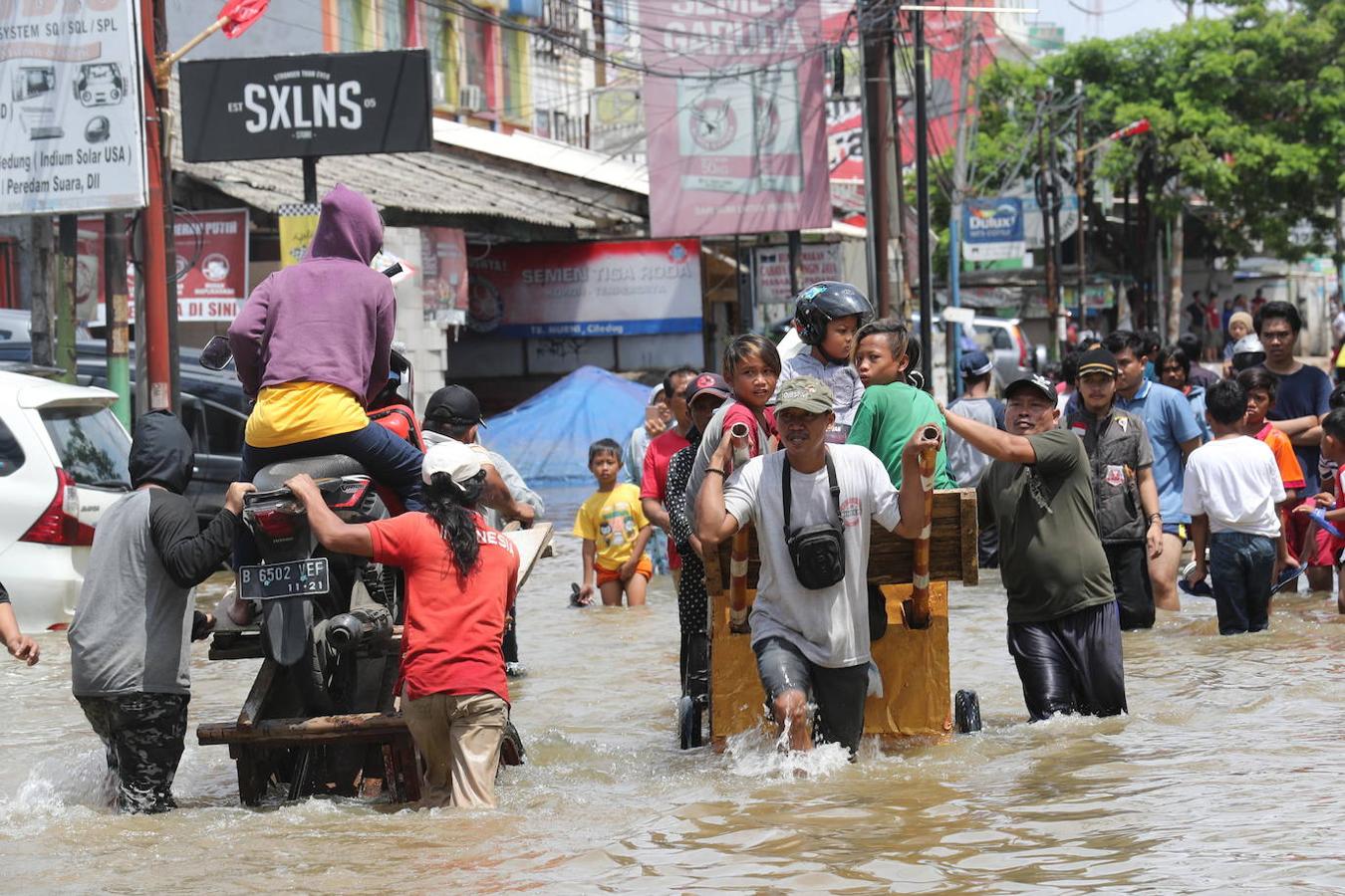 Un grupo de personas atraviesa las calles inundadas de Yakarta, Indonesia.