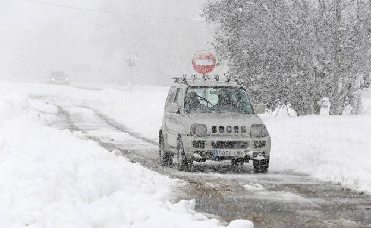 Un vehículo circula entre la nieve en una imagen de archivo.
