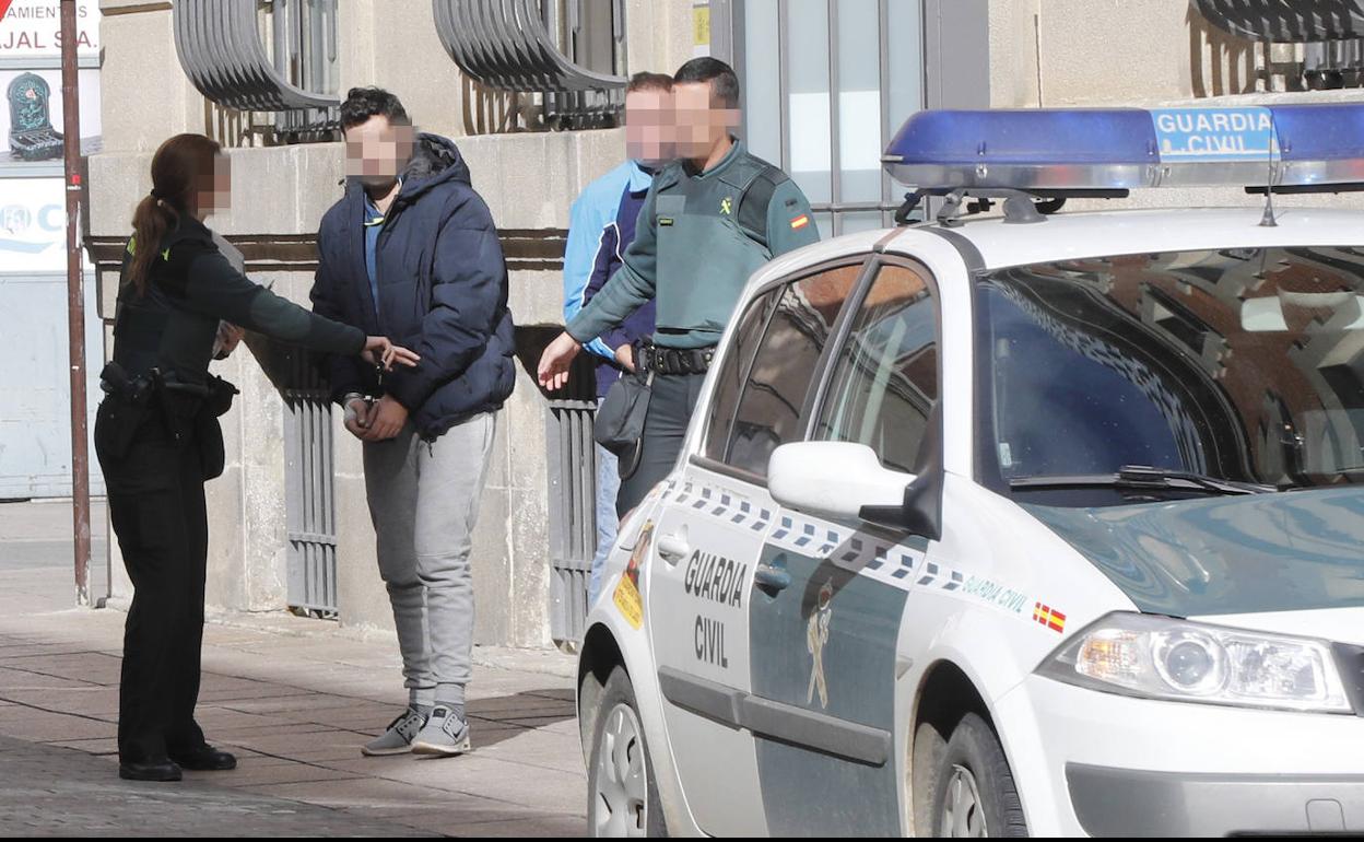 El detenido, ayer a la salida de los juzgados, conducido por la Guardia Civil. A la derecha, exterior de la casa, el miércoles.
