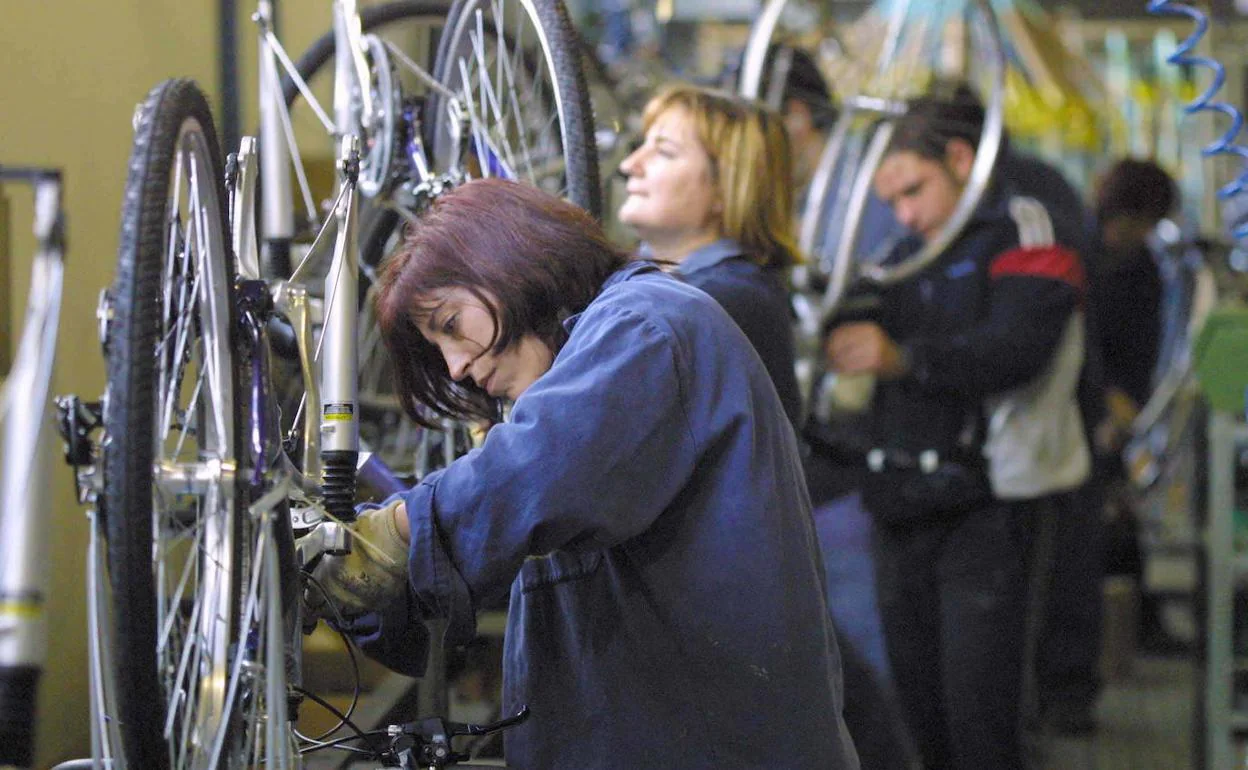 Varios trabajadores en una fábrica de bicicletas.