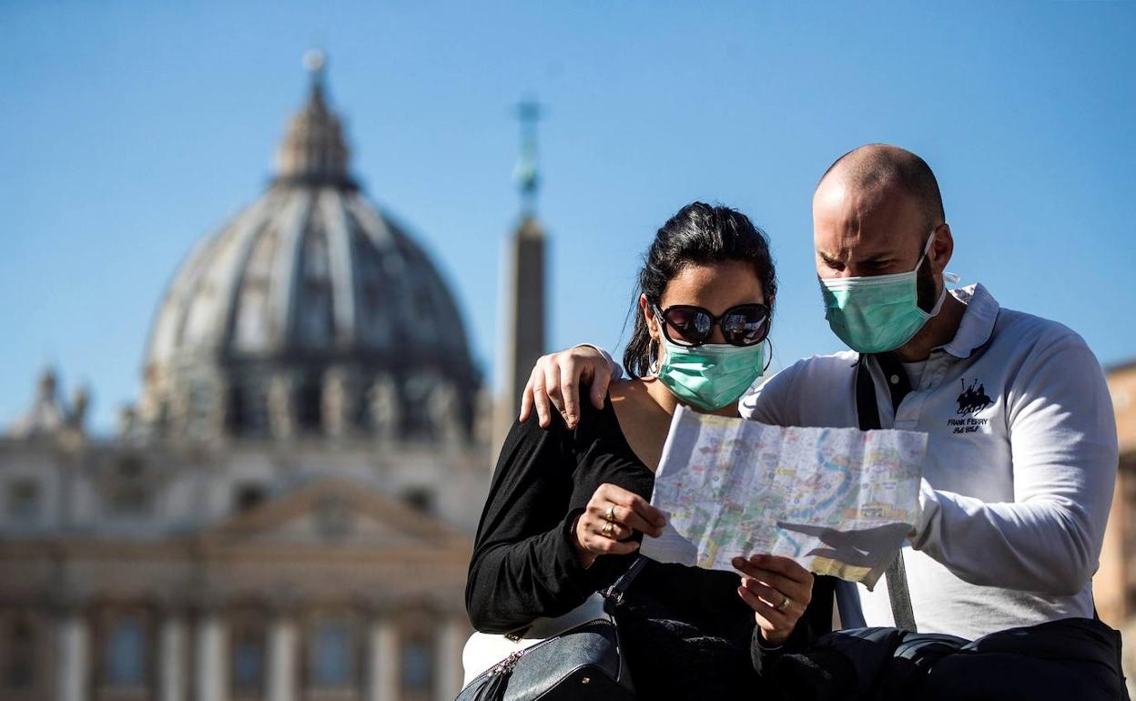 Una pareja observa un plano de espaldas al Vaticano.