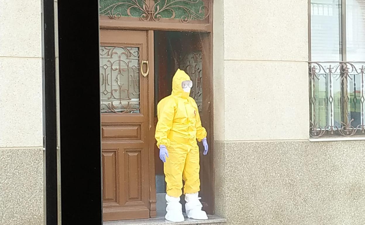 Un sanitario de emergencias, con el traje de protección, en la puerta de la casa de la familia zamorana.