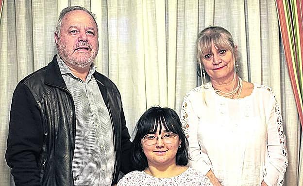 Emilia, que ahora tiene 24 años, posa con sus padres de adopción, Manuel Luna y Mercedes Campos.