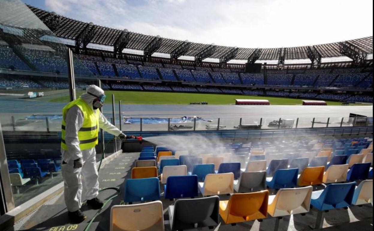 Un empleado desinfecta asientos en el estadio de San Paolo. 