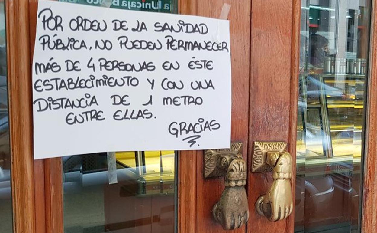 Cartel solicitando mantener la distancia de seguridad entre clientes de un establecimiento comercial.