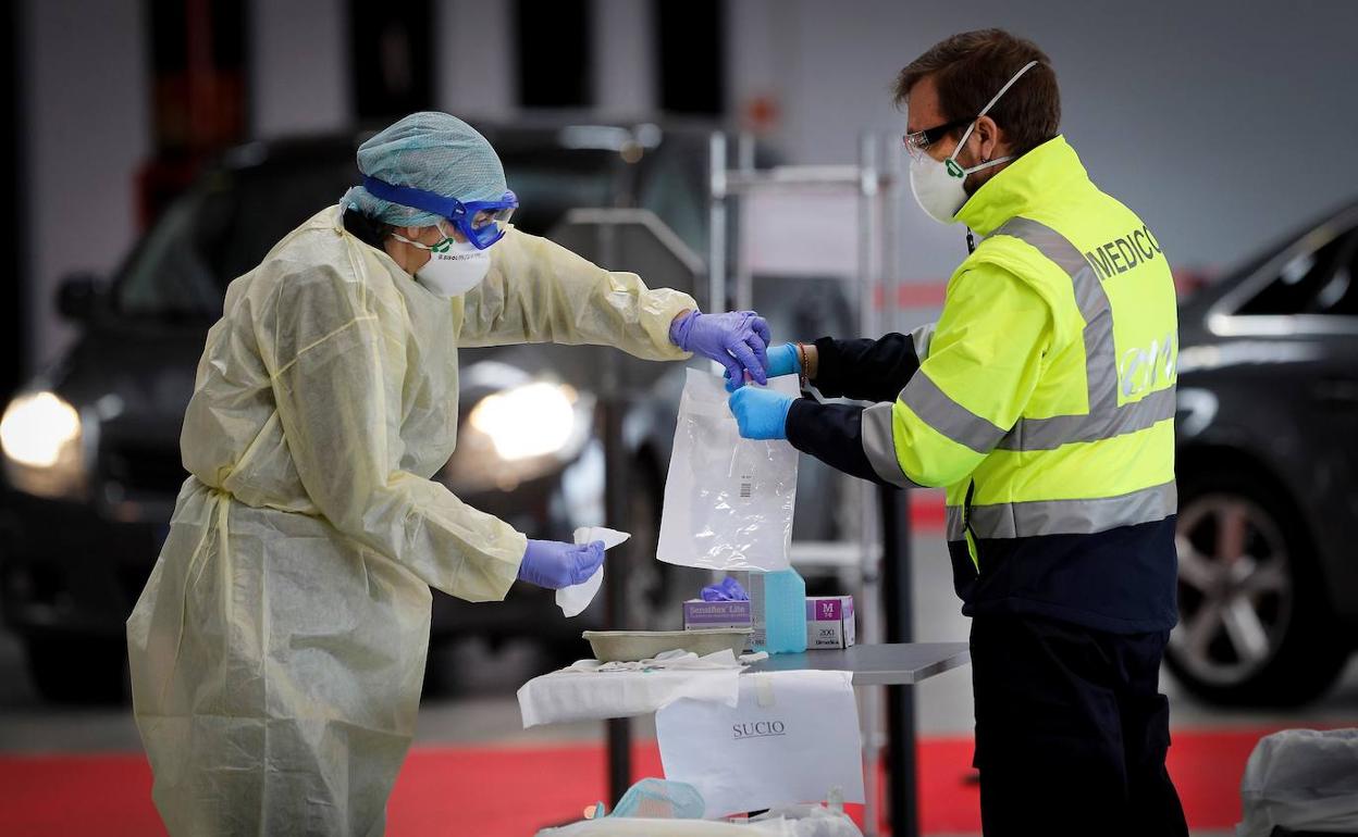 Una enfermera y un médico recogen una muestra para realizar el test de coronavirus. 