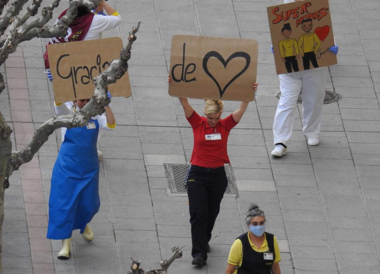 Trabajadores de los supermercados en la barriada de Eras de Renueva salen a la calle para aplaudir a los vecinos. Corazones y gratitud al aire para animar a los residentes en el duro confinamiento.