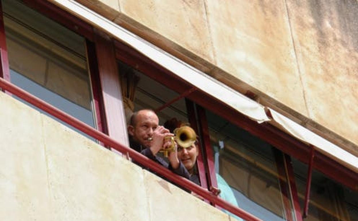 Un hombre toca la trompeta desde la ventana de su casa en Alicante durante el confinamiento. 