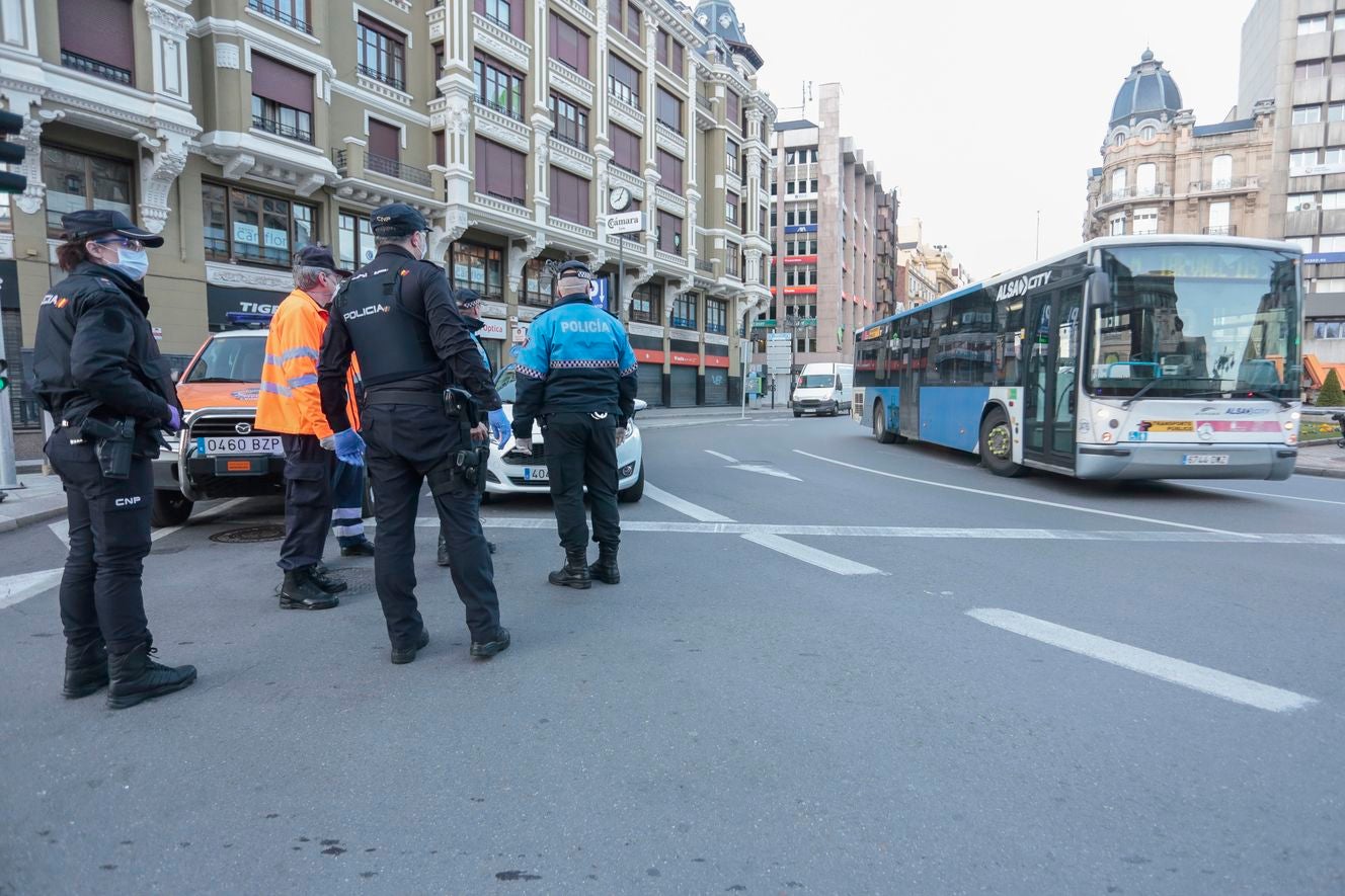 Miembros de Policía Local, Policía Nacional y Protección Civil de León, reparten mascarillas a usuarios del transporte público.