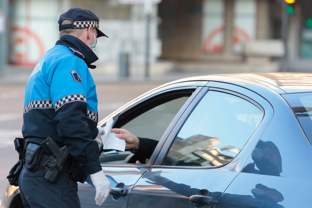 Miembros de Policía Local, Policía Nacional y Protección Civil de León, reparten mascarillas a usuarios del transporte público.