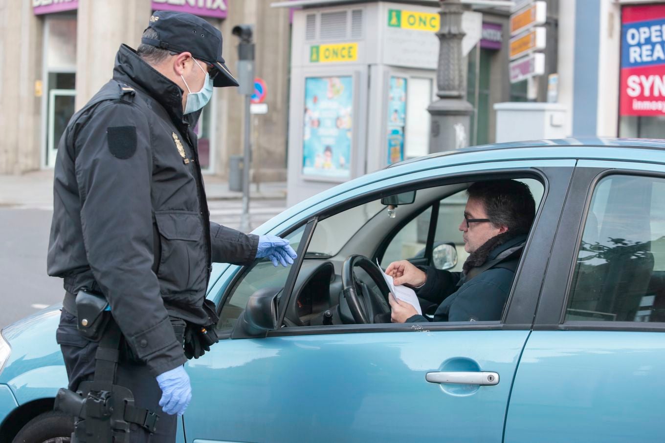 Miembros de Policía Local, Policía Nacional y Protección Civil de León, reparten mascarillas a usuarios del transporte público.