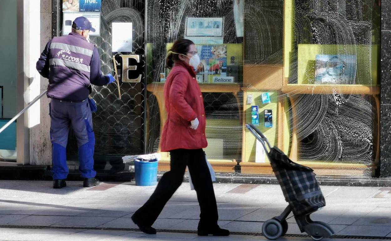 Un trabajador limpia un comercio este viernes en León capital.