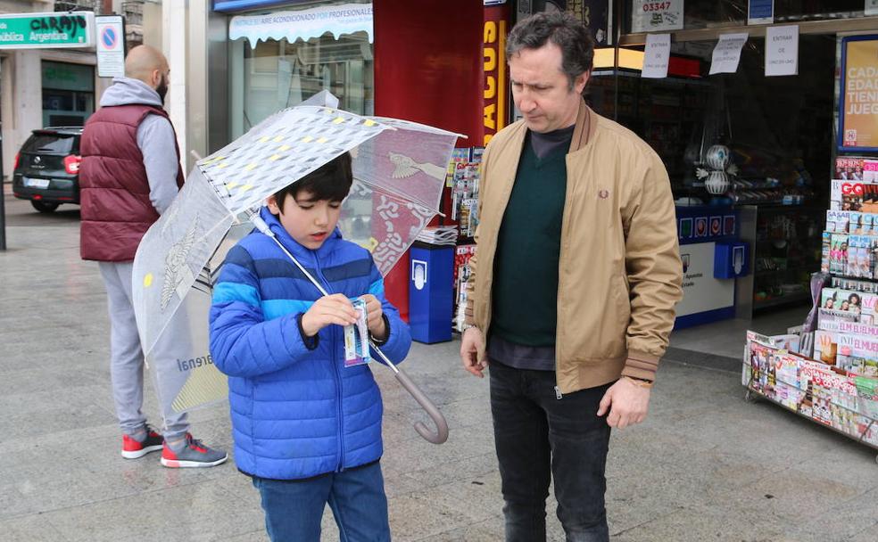 Álvaro abre un paquete de cromos junto a su padre este domingo.