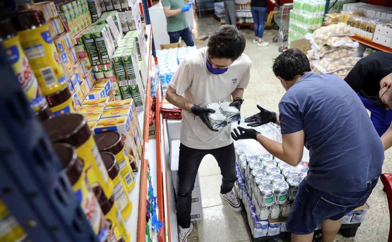 Trabajadores reponiendo productos en un supermercado. 