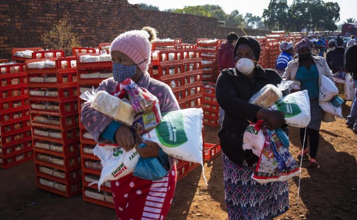 Personas reciben comida druante la pandemia de coronavirus 