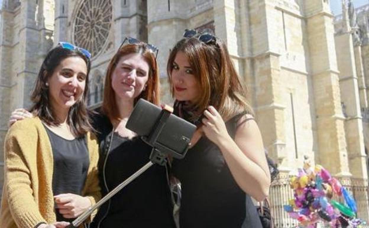 Tres turistas se fotografían ante la Catedral de León, 