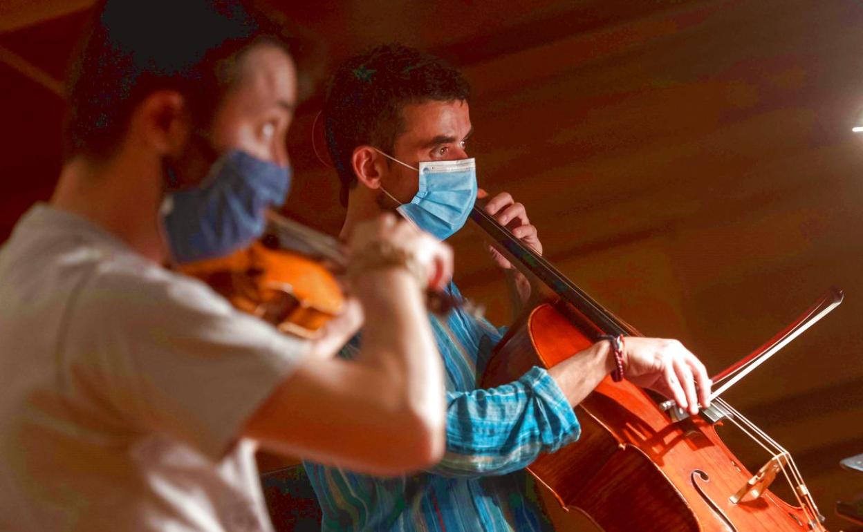 Dos miembros de la orquesta tocando.