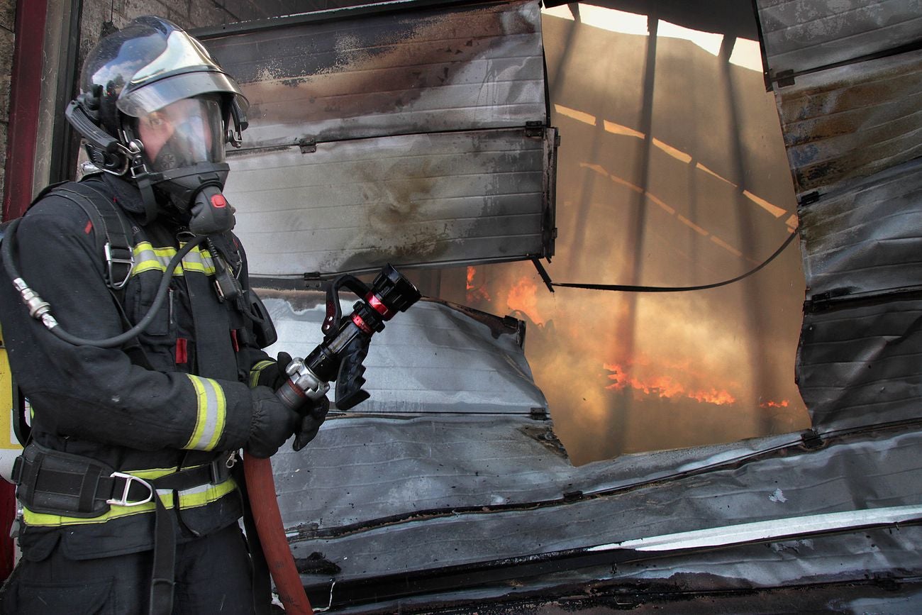 Efectivos del Cuerpo de Bomberos de León intervienen en un incendio originado en una nave en el municipio de Valverde de la Virgen. 