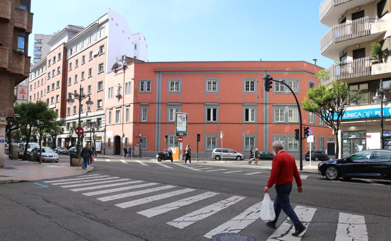 Un señor cruza un una calle en la capital. 