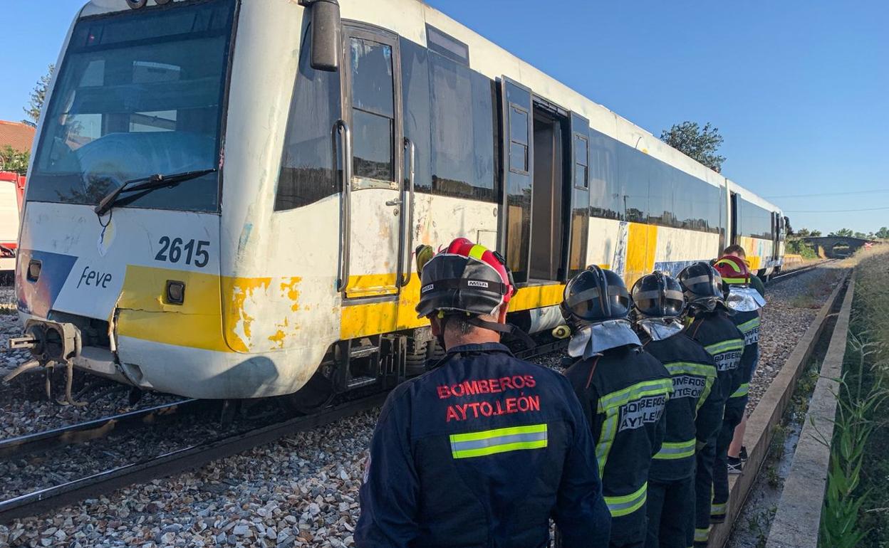 Efectivos de Bomberos León junto a la unidad de Feve averiada.