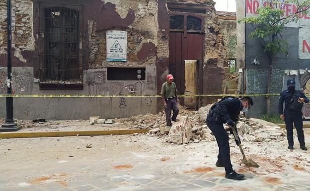 Policías y miembros de Protección Civil levantan parte de una barda derrumbada en la ciudad de Oaxaca (México).