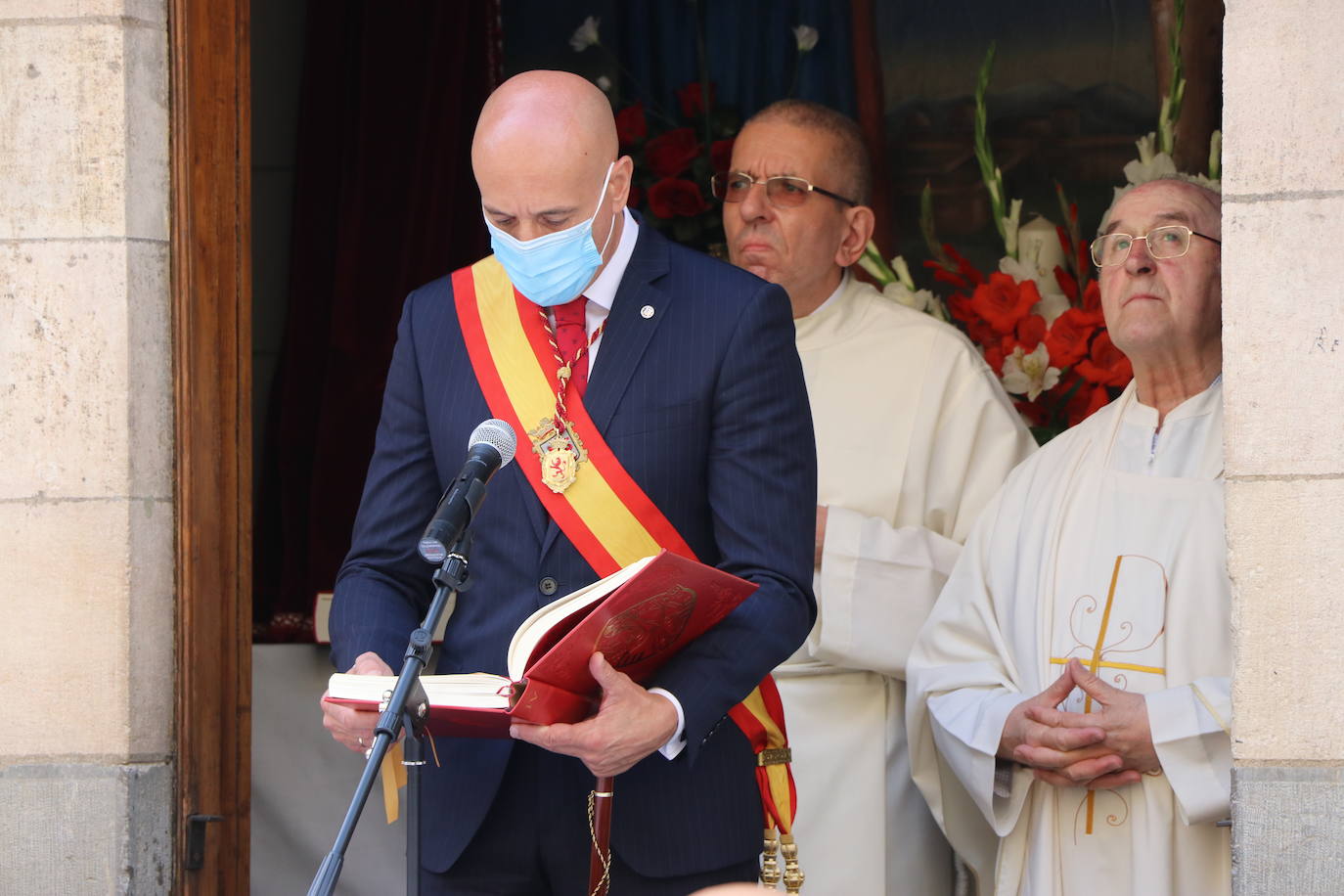 Unas mujeres reciben la comunión mientras portan mascarillas.
