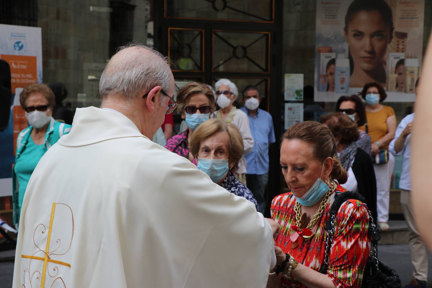 Unas mujeres reciben la comunión mientras portan mascarillas.