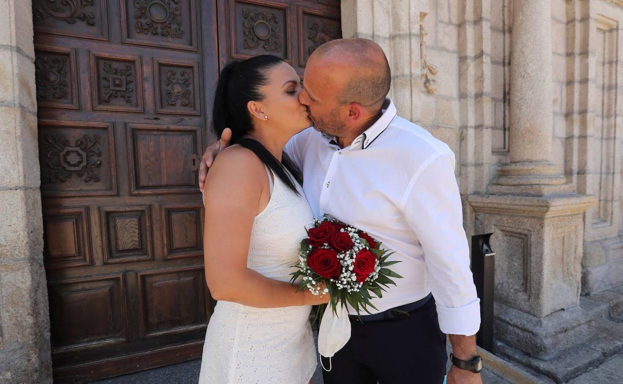 Una pareja se besa en la puerta de la iglesia. 