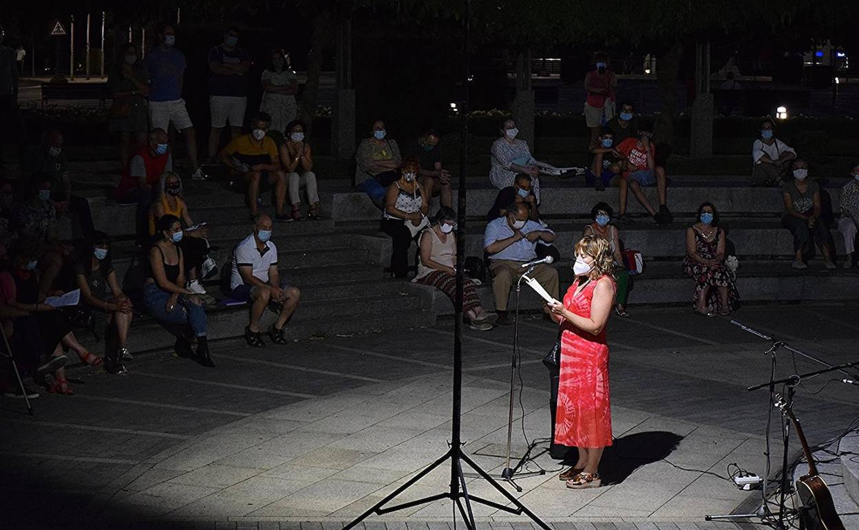 Una mujer recita con mascarilla en el Ágora de la Poesía.