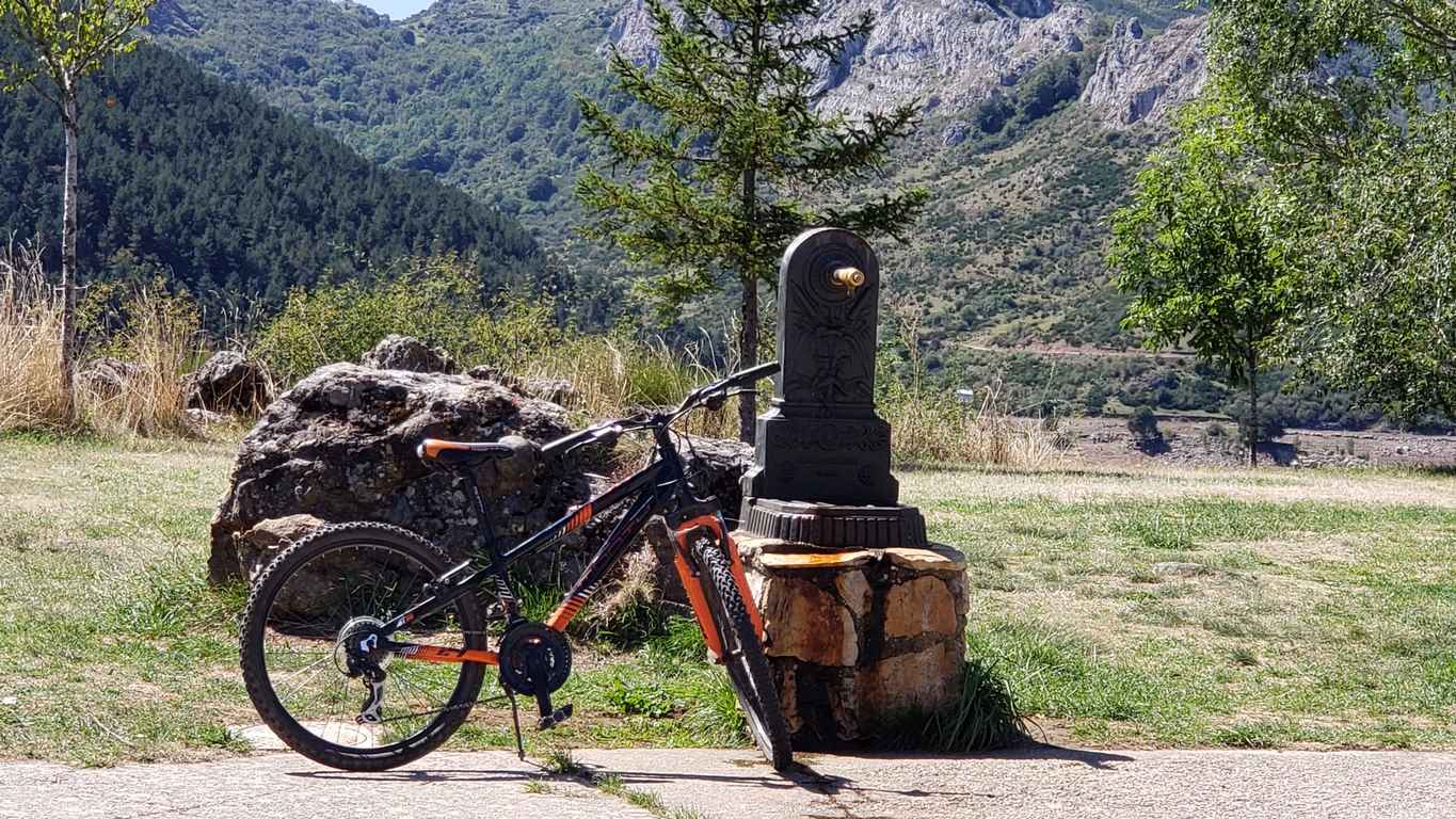 Ubicado junto a la Ermita de Nuestra Señora, en Riaño, el banco ofrece unas privilegiadas vistas sobre el pantano y Picos | El entorno, con las viejas campanas y un 'horreo leonés', completa un escenario idílico. 