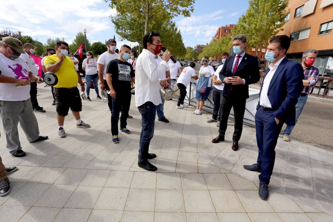 El líder autonómico socialista, Luis Tudanca, y el procurador José Luis Vázquez, conversan con el portavoz del colectivo de feriantes que ha protagonizado una cacerolada ante las Cortes de Castilla y León. 