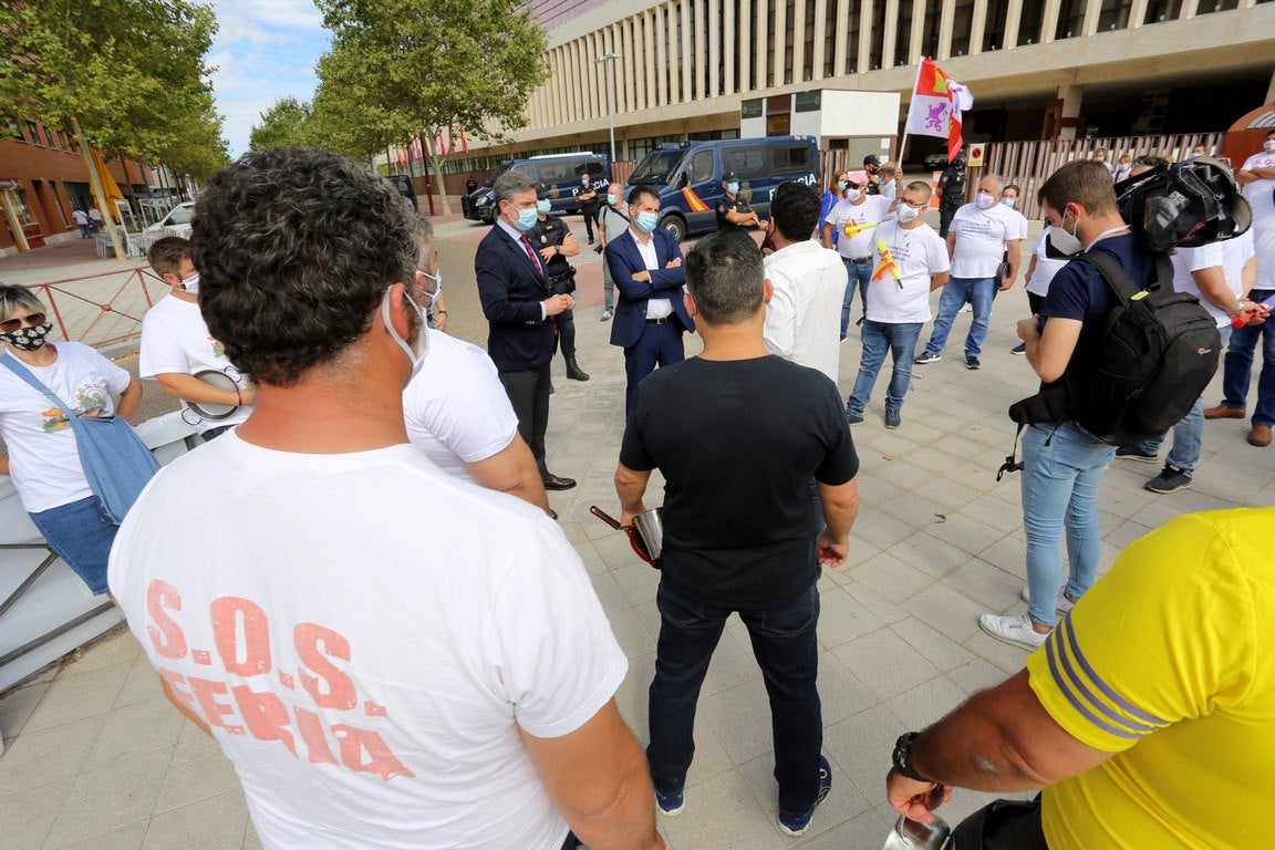 El líder autonómico socialista, Luis Tudanca, y el procurador José Luis Vázquez, conversan con el portavoz del colectivo de feriantes que ha protagonizado una cacerolada ante las Cortes de Castilla y León. 