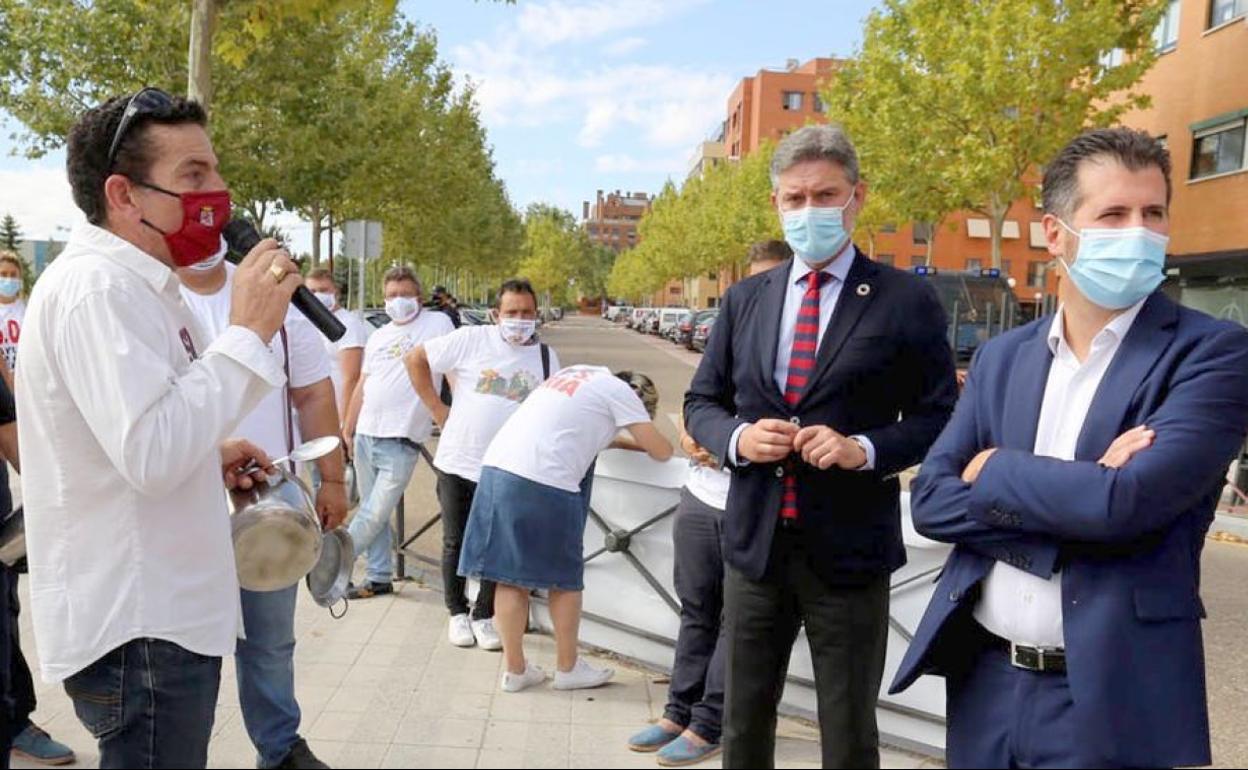 El líder autonómico socialista, Luis Tudanca, y el procurador José Luis Vázquez, conversan con el portavoz del colectivo de feriantes que ha protagonizado una cacerolada ante las Cortes de Castilla y León. 