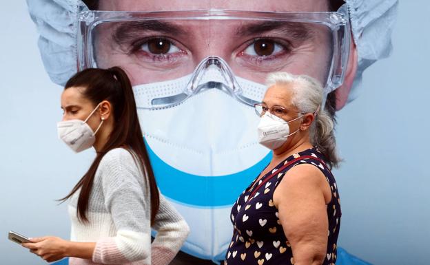 Dos mujeres caminan con mascarillas en Vallecas.