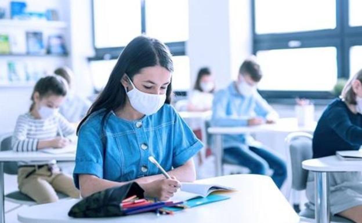 Una estudiante con mascarilla en un aula. 