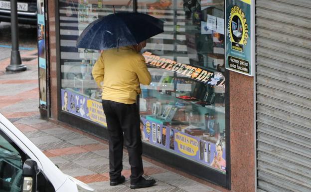 Un hombre contempla un escaparate en León. 