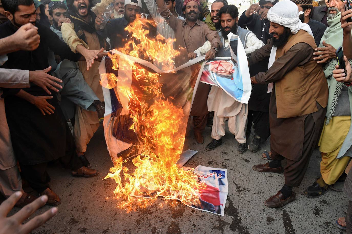 Manifestantes queman fotografías de Macron en Quetta, Pakistán.