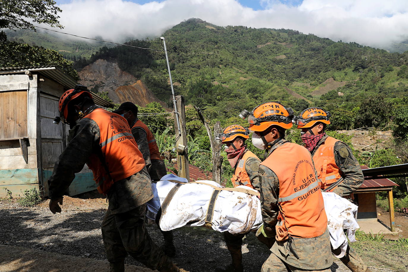 Soldados llevan un cuerpo recuperado de una zona afectada por un deslizamiento de tierra, provocado por las fuertes lluvias traídas por la tormenta Eta, mientras continúa la búsqueda de víctimas en la aldea enterrada de Queja.