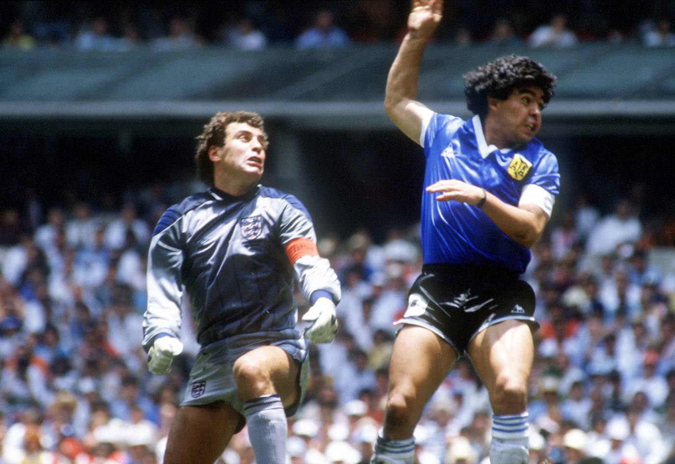 Diego Armando Maradona, futbolista de Argentina,supera, con la mano ("la mano de Dios") la salida del portero Shilton, de Inglaterra, durante un partido de los cuartos de final del Mundial de México 1986.