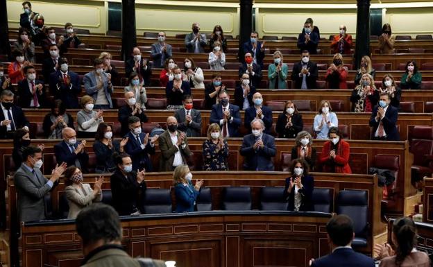 Los diputados del PSOE y Unidas Podemos aplauden a la ministra María Jesús Montero tras la votación.