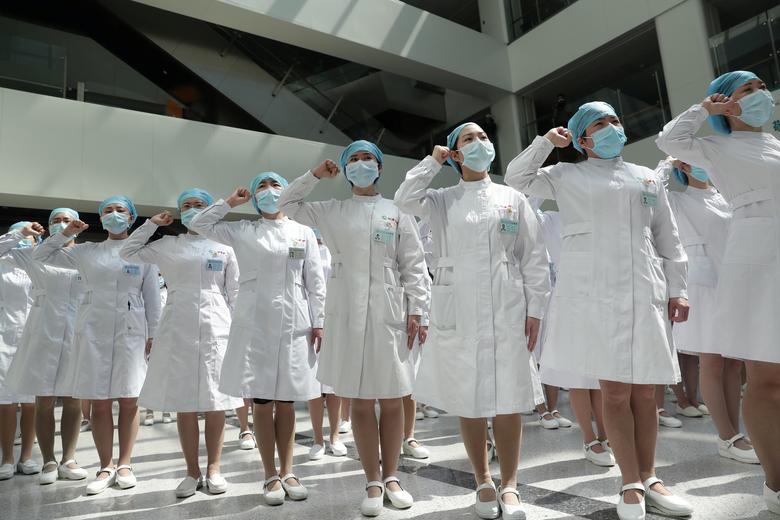 China. Enfermeras con mascarillas participan en un evento celebrado para conmemorar el Día Internacional de las Enfermeras, en el Hospital Wuhan Tongji en Wuhan, la ciudad china más afectada por el brote de coronavirus, en la provincia de Hubei