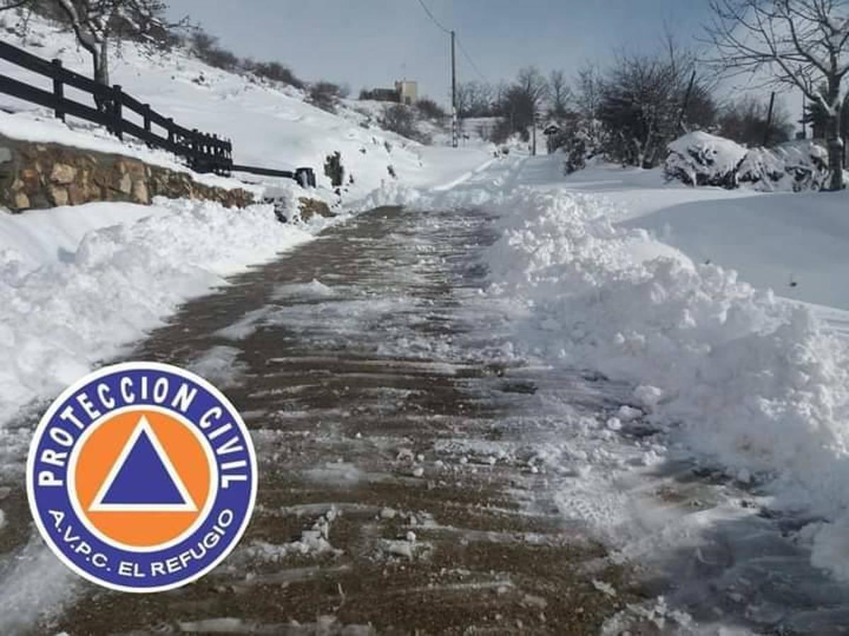 Los voluntarios de Protección Civil despejan la nieve caída en los últimos días en Ferreras del Puerto.